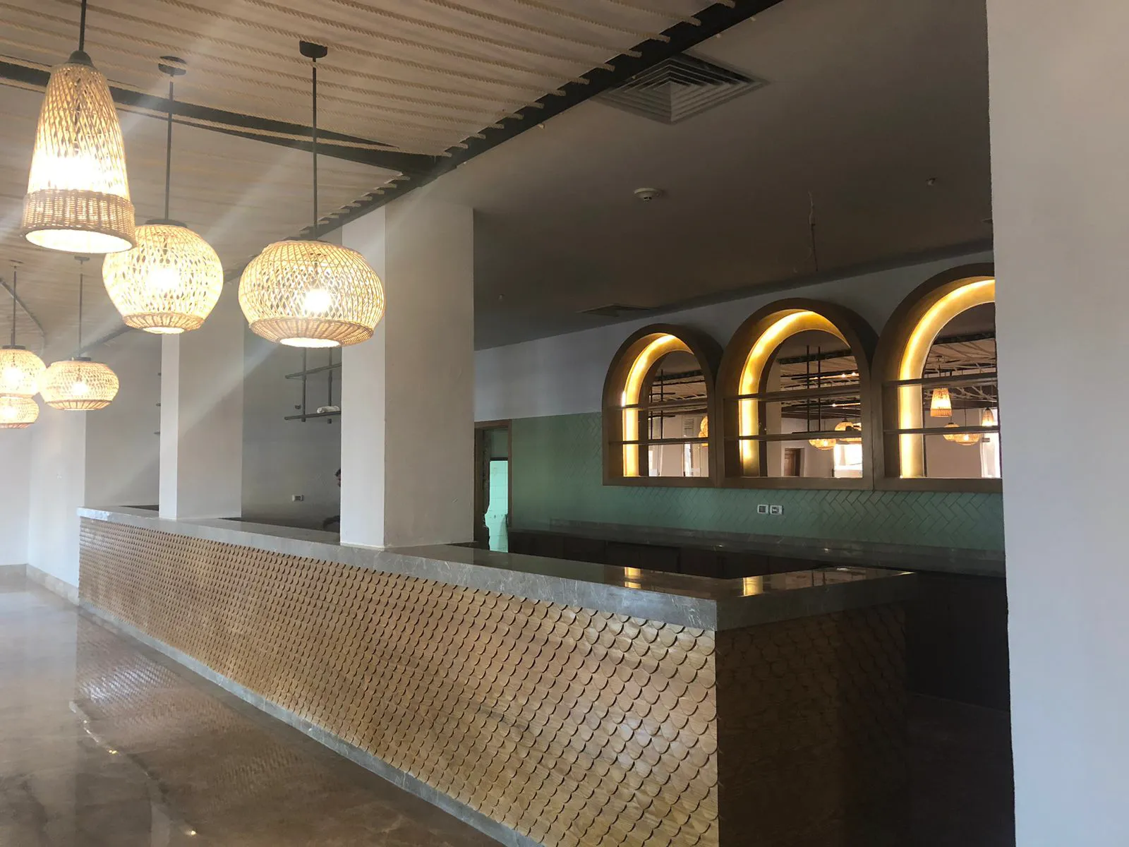 Eldora hospitality lobby with woven pendant lighting and an arched reception