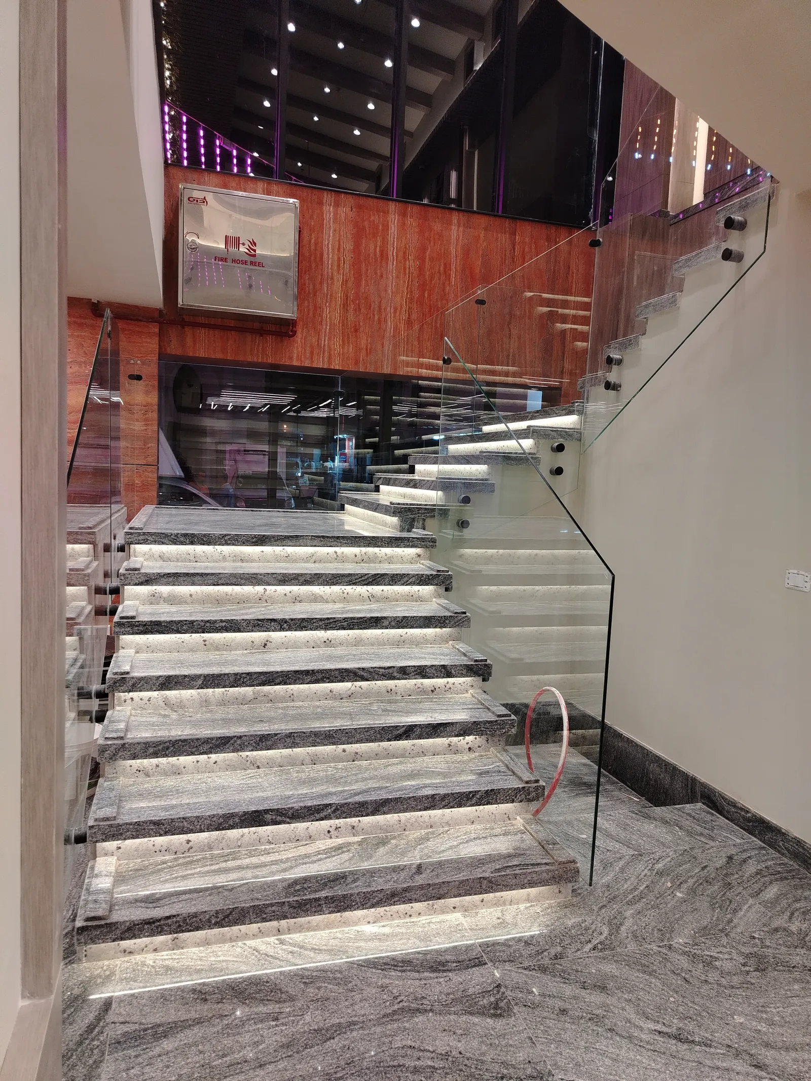 Slate feature wall with brass inlay and floating glass-railed stair, finished by Eldora Constructions